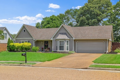 View of front of home featuring an attached garage, concrete driveway, a shingled roof, and a front lawn