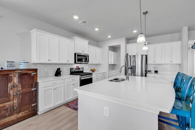 Kitchen featuring visible vents, a sink, stainless steel appliances, light wood-style floors, and light countertops