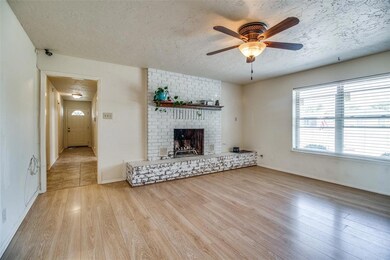 Spacious living room with wood burning fireplace.  Down the hallway is the laundry room, office and guest bedroom.  Kitchen is to the left.