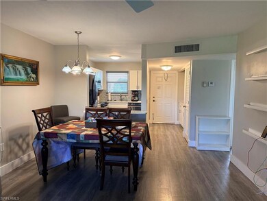 Dining space featuring dark wood-type flooring and a chandelier