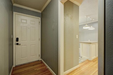 Entryway with crown molding and light wood-type fl