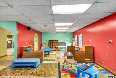 Miscellaneous room featuring arched walkways and a drop ceiling