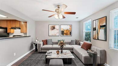 Living area featuring baseboards, a ceiling fan, 