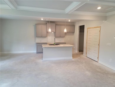 Kitchen featuring gray cabinetry, finished concrete floors, a kitchen island with sink, a sink, and ornamental molding