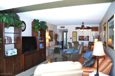 Carpeted living room with ceiling fan