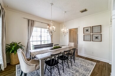 The dining room is bathed in abundant natural sunlight streaming in through two sides and above the table area, you'll notice a pair of creamy candelabra chandeliers that add a charming ambiance to the space.