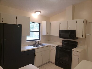 Spacious kitchen with sleek refrigerator, stove, d