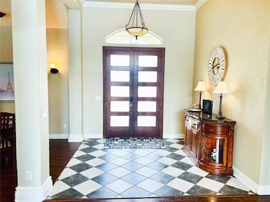 Entryway featuring ornamental molding and a textured wall