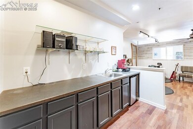 Kitchen featuring a sink, open shelves, stainless 