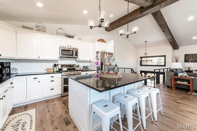 Kitchen featuring a chandelier, white cabinetry, a kitchen island, recessed lighting, and appliances with stainless steel finishes