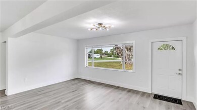 Foyer entrance with light wood-style floors and a chandelier