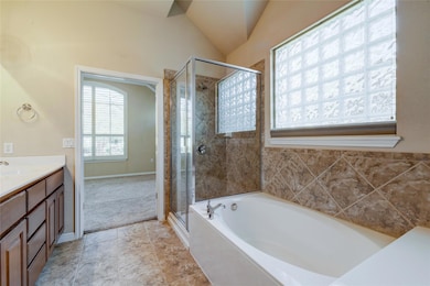 Bathroom featuring a bath, a stall shower, vanity