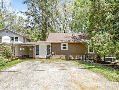 Side of house with ample parking for 2-3 cars; small carport great for bikes, kayaks or extra storage & side entrance into mud room/laundry.