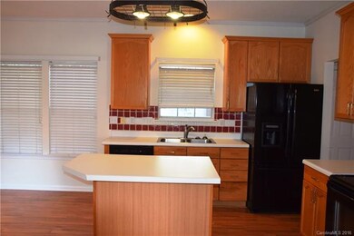 Kitchen features an island and pot rack.