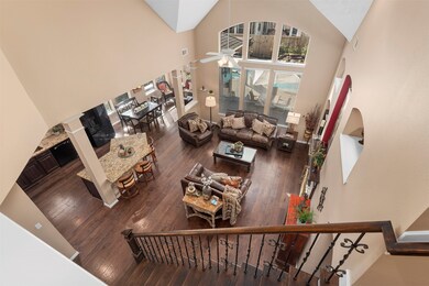 The view from the top of the stairs shows the wow factor in this home.  The floors are all wood, the stairs were custom made wood and iron, the kitchen is all updated and the large windows frame the beautiful pool and spa.  Imagine yourself living here.