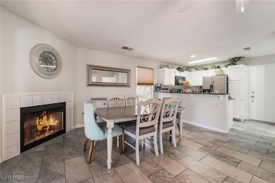 Dining space with a tile fireplace, recessed light