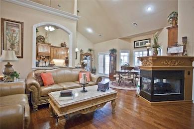 Living area, open floor plan with well maintained wood flooring