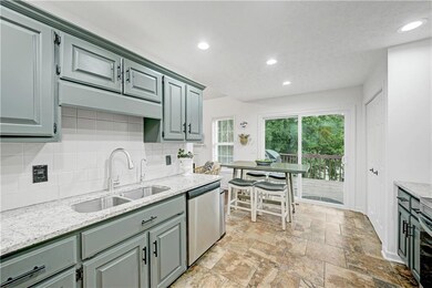 Kitchen featuring dishwasher, backsplash, recessed lighting, light stone finish floors, and light stone counters