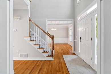 Foyer featuring stairs, visible vents, crown moldi