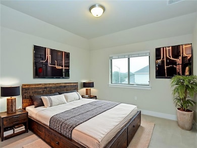 Bedroom with baseboards and light colored carpet