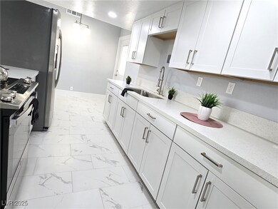 Kitchen featuring a sink, marble finish floor, ele