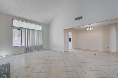 Unfurnished room with a textured ceiling, a chande
