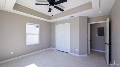 Unfurnished bedroom with visible vents, a tray ceiling, and baseboards