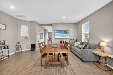 Dining room with light wood-type flooring and recessed lighting