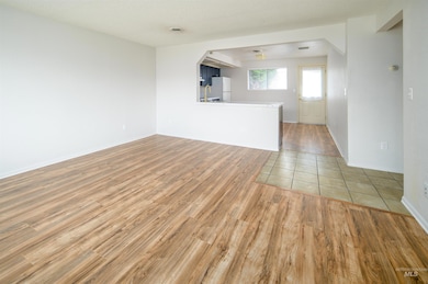 Unfurnished living room featuring light wood-style floors and baseboards