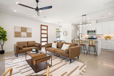 Living room with concrete flooring, a ceiling fan