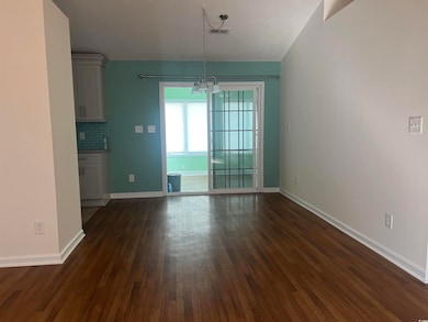 Unfurnished dining area with dark wood-type flooring and a chandelier