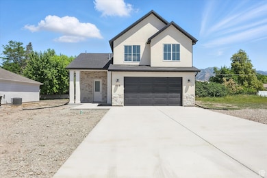 View of front of property with an attached garage, concrete driveway, stucco siding, and stone siding