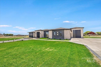View of front of house with concrete driveway, a front lawn, a garage, and stucco siding