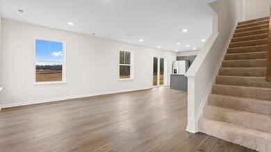 Open 1st floor living room and kitchen in a DRB Homes Glenshaw plan at The Village of College Park.