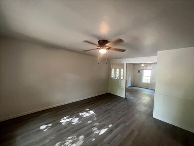 Unfurnished room with ceiling fan and dark hardwoo