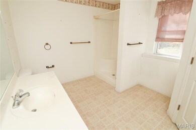Full bathroom featuring a stall shower, vanity, and light flooring