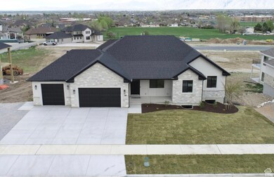 View of front of home featuring stone siding, an attached garage, a shingled roof, and driveway