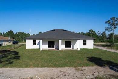 Rear view of house with stucco siding, a patio, an