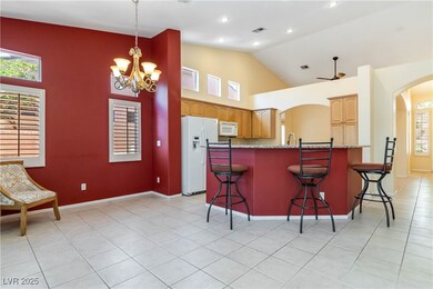 Kitchen with white appliances, arched walkways, li