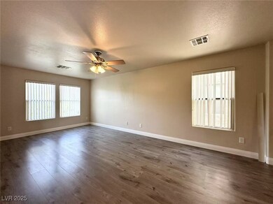 Spare room with a ceiling fan, dark wood-style flo