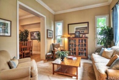 Formal living room with crown molding, cased windo