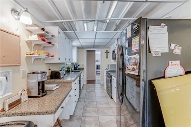 Kitchen featuring freestanding refrigerator, open