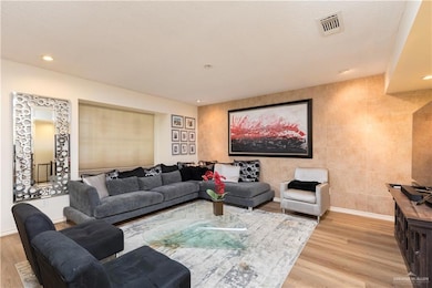 Living area featuring wood finished floors and recessed lighting