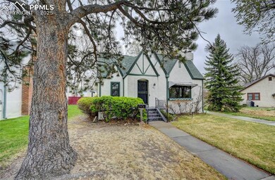 Tudor home featuring a front yard, a shingled roof