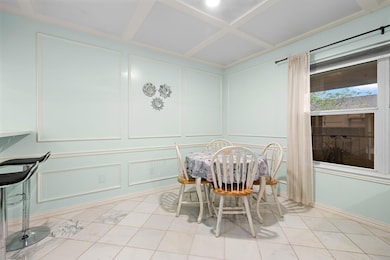 Dining space with a decorative wall and coffered 