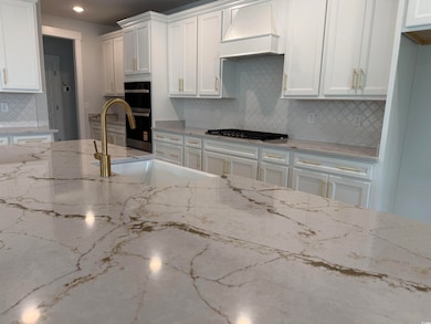 Kitchen featuring white cabinets, stainless steel 