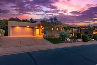 Pueblo-style house with stucco siding, driveway, and an attached garage