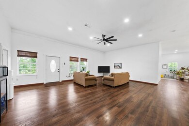Living room featuring ceiling fan, dark wood-style