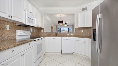 Kitchen with white appliances, crown molding, whit
