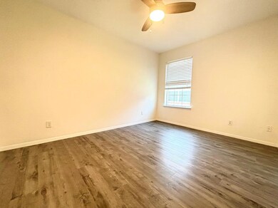 Empty room with vaulted ceiling, ceiling fan, and 